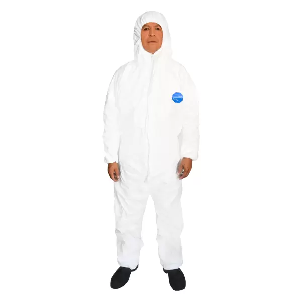 Una persona que lleva un traje protector blanco con capucha, de pie sobre un fondo completamente blanco. El traje tiene cremallera completa y un logo azul visible en el pecho. Se ven zapatos negros.