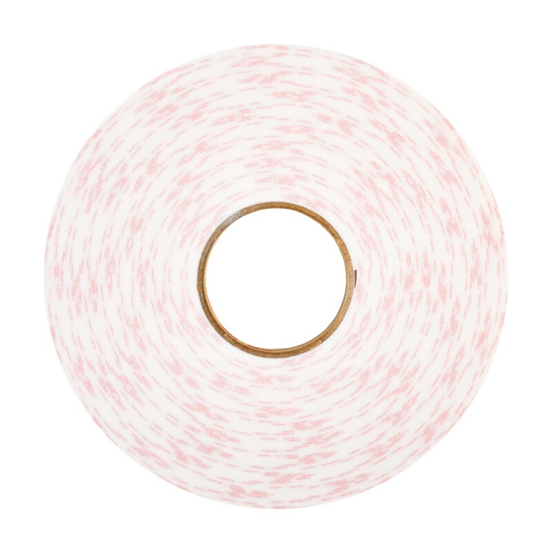 Un rollo de cinta adhesiva moteada de blanco y rojo visto desde arriba, que muestra los círculos concéntricos de las capas alrededor de un tubo de cartón central. los colores sugieren un patrón ligeramente moteado en todo el rollo.