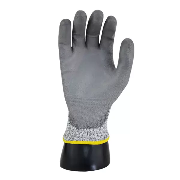 Un guante resistente a cortes con una capa gris en la palma y los dedos, y una base tejida en blanco y gris. el guante está montado sobre un soporte negro con un borde amarillo en la muñeca.