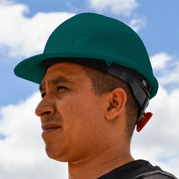 Una vista de perfil de un hombre que llevaba un casco verde azulado contra un cielo parcialmente nublado. está concentrado, con una expresión seria, mostrando un primer plano de sus rasgos iluminados de manera destacada por la luz solar natural.