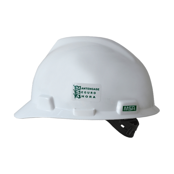 Un casco de seguridad blanco con una correa para la barbilla en el lado izquierdo. El casco tiene un logo verde y negro con el texto "mantengase seguro ahora" y "msa". El diseño del casco es resistente con una superficie lisa y curva.