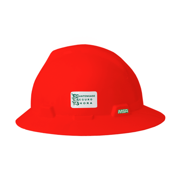 Un casco de seguridad de color rojo brillante con una pegatina verde y blanca en el frente que dice "manténgase seguro a la hora" encima del logotipo de un reloj, que indica un enfoque en la seguridad por horas, fabricado por msa.